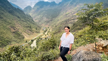 Traveller stood at viewpoint with mountains and valley of the Ha Giang Loop in background, Ha Giang Loop, Vietnam