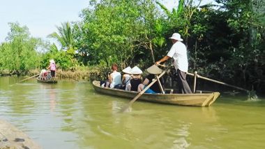 Travellers on a local boat at the Mekong Delta in Vietnam