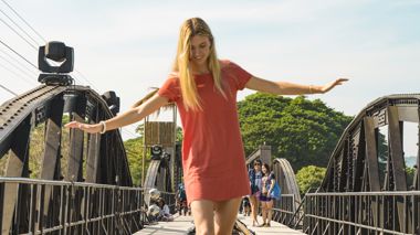 Traveller walking on a railway on the Bridge over the River Kwai in Kanchanaburi, Thailand