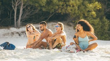 Travellers sitting on Airlie Beach in the Whitsunday region, Australia