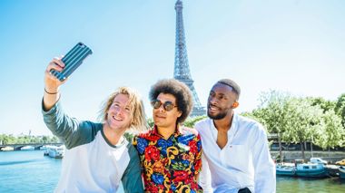 Travellers taking a selfie in front of the Eiffel Tower