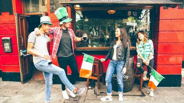 Travellers dancing with a pint of Guinness at a pub in Dublin, Ireland