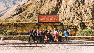 Group of Travellers in front of the Inca Trail sign in Peru