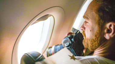 Traveller taking a photo out of the aeroplane window in Puerto Maldonado, Peru