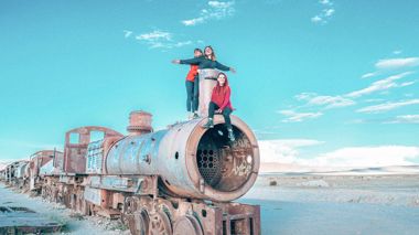 Travellers on a rusted train in Uyuni, Bolivia