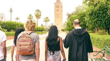 Travellers with the local guide at the Koutoubia Mosque in Marrakech, Morocco