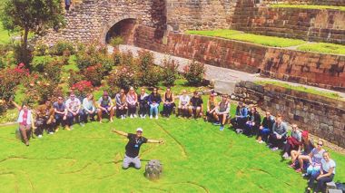 Group of Travellers sat at Coricancha Temple in Cusco, Peru