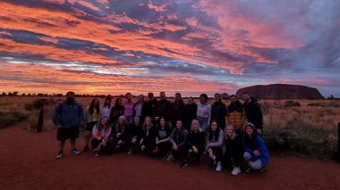 Travelers during sunrise at Uluru in Australia
