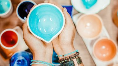 Traveller holding ceramics sold at the Iraq Al Amir Women's Co-Op in Amman, Jordan
