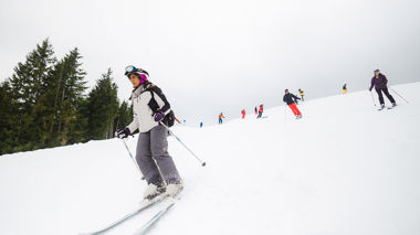 Travellers skiing down the slopes, Hopfgarten, Austria