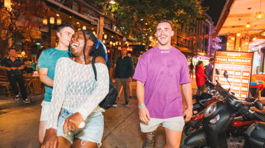 Travellers walking and laughing on Khao San road, Bangkok, Thailand