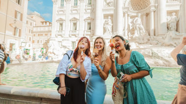 Travellers holding gelato in front of the Trevi fountain, Rome, Italy