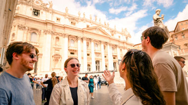 Four travellers standing in front of St. Peter's Basilica in the Vatican City
