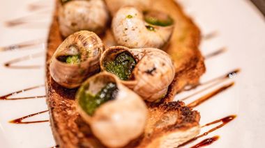 Snails cooked in garlic butter served with crusty french bread in Paris, France
