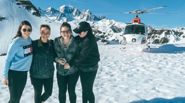 Travellers in front of helicopter before their scenic flight in over the Franz Josef Glacier, New Zealand