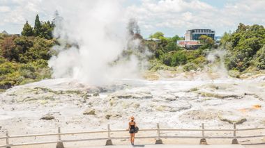 Traveller looking upon the bubbling Geothermic mud pools in Rotorua, New Zealand