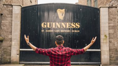 Traveller in front of Guiness Brewery sign in Dublin, Ireland