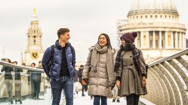 Travellers walking over the Millennium bridge in London, England