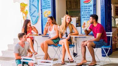Travellers eating food at a local café in Mykonos, Greece