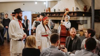 Travellers eating a local meal during a traditional Slovenian Evening in Ljubljana, Slovenia
