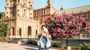 Traveller taking photo in front of the Seville Cathedral in Seville, Spain