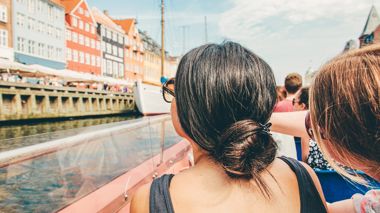 Traveller pointing at buildings in Nyhaven, Copenhagen, Denmark