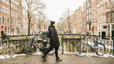 Traveller walking over a bridge during winter in Amsterdam, Netherlands