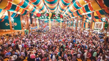 Travellers experiencing Oktoberfest in an Oktoberfest tent in Munich, Germany