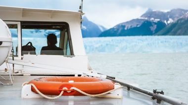 Traveller sat on a boat in front of a glacier in Balmaceda, Puerto Natales, Patagonia, Chile