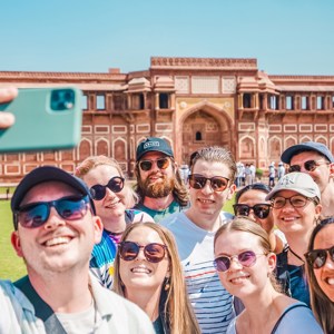 Ten travellers taking a picture outside of Agra Fort in Agra, India
