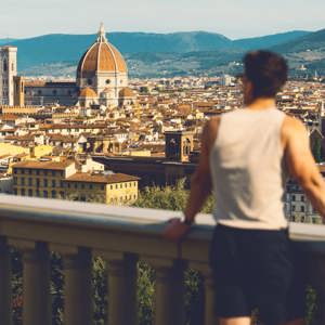 Traveller at Piazzale Michelangelo overlooking the Florence skyline with Brunelleschi's Duomo and Campanile in Tuscany Italy - Contiki European Discovery Tour