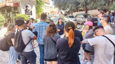 Travellers listening to local guide in cobblestone street during a walking tour of Tbilisi, Georgia