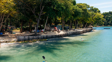 Travellers canoeing in the sea at Ara Dinawan Island, Borneo, Malaysia
