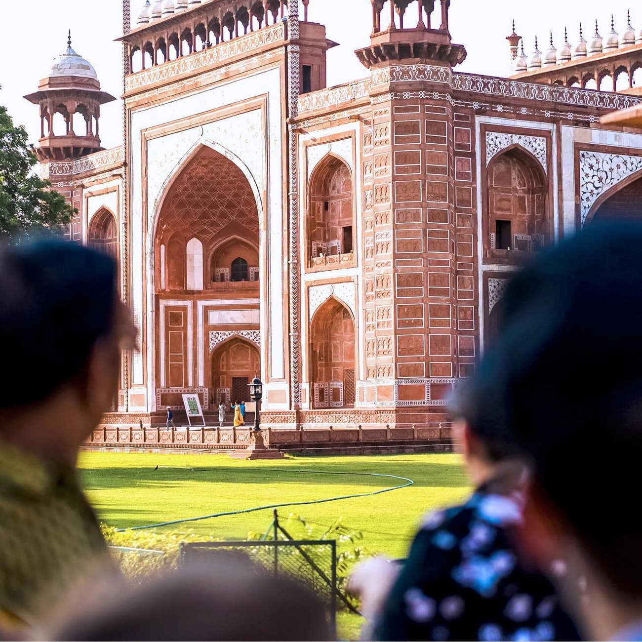 Travellers viewing the ornate red sandstone Great Gate entrance to the Taj Mahal in Agra India - Contiki India Northern Explorer Tour