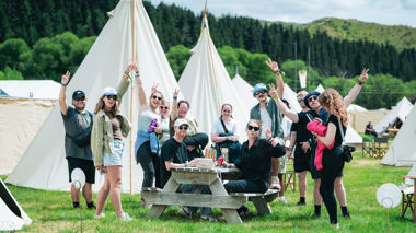 Travellers stood outside of tents at Rhythm & Alps Festival, Wānaka, New Zealand
