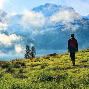 Traveller hiking through the Austrian Alps with panoramic mountain views on the Contiki Active Austrian Alps Tour