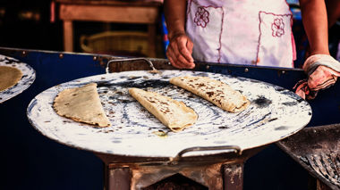 Folded quesadillas cooking on a large metal street comal, Mexico City, Mexico
