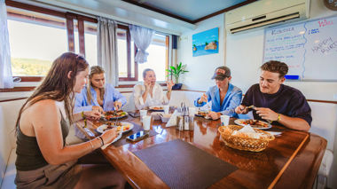 Travellers enjoying a locally sourced meal on the sail boat, Croatia
