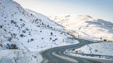 Road winding through snow covered mountains in Queenstown, New Zealand
