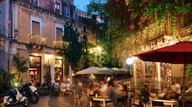 A busy street lit up by fairy lights in Catania, Italy