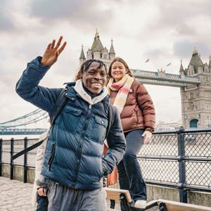 Contiki ravellers posing in front of Tower Bridge in London on Contiki's England in a Week Tour, exploring one of England's most iconic landmarks