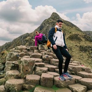 Travellers explore the Giant's Causeway, with its iconic basalt columns and dramatic coastal landscape, on the Contiki Best of Great Britain & Ireland Tour