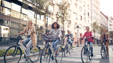 Five travellers rising bikes along a city street in Tallinn, Estonia