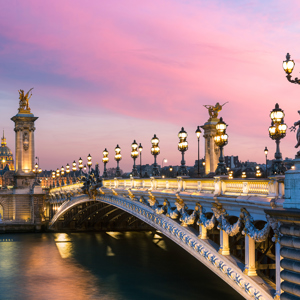 Pont Alexandre III bridge at sunset from the riverbank in Paris, France