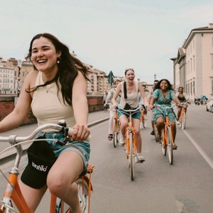 Contiki travellers cycling through the historic streets of Florence, Italy, on the Vienna to London Trail Tour