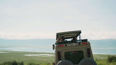 Safari truck driving down a dirt road in Serengeti, Tanzania