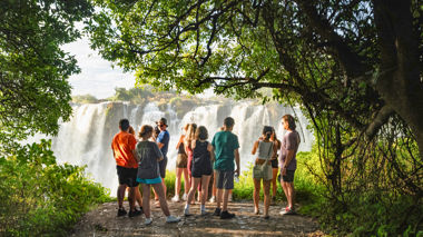 Travellers admiring Victoria Falls from viewpoint, Zambia