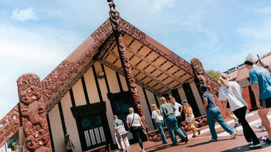 A group of travellers walking into the Marae Special Stay in Rotorua, New Zealand