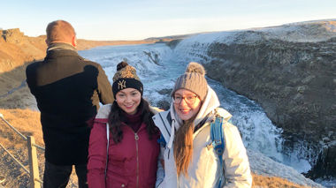 Travellers standing at viewing point of Gullfoss Falls, Iceland