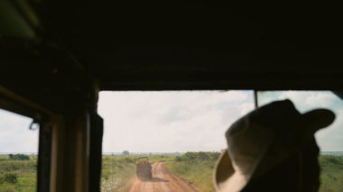 Traveller sitting in safari truck on a dirt road in South Africa